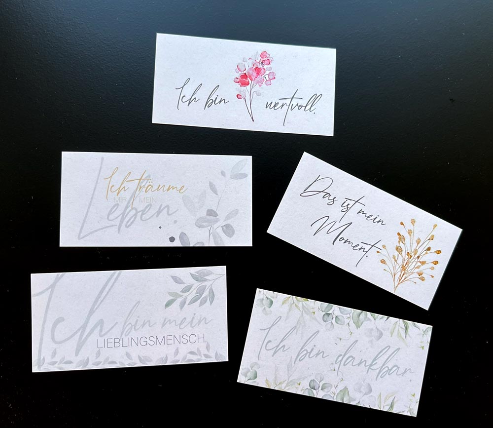 seiDU Karten-Set von A.D. WiLK: fünf Kärtchen mit Affirmationen wie »Ich bin wertvoll«, »Das ist mein Moment« und floralen Illustrationen auf dunklem Untergrund.