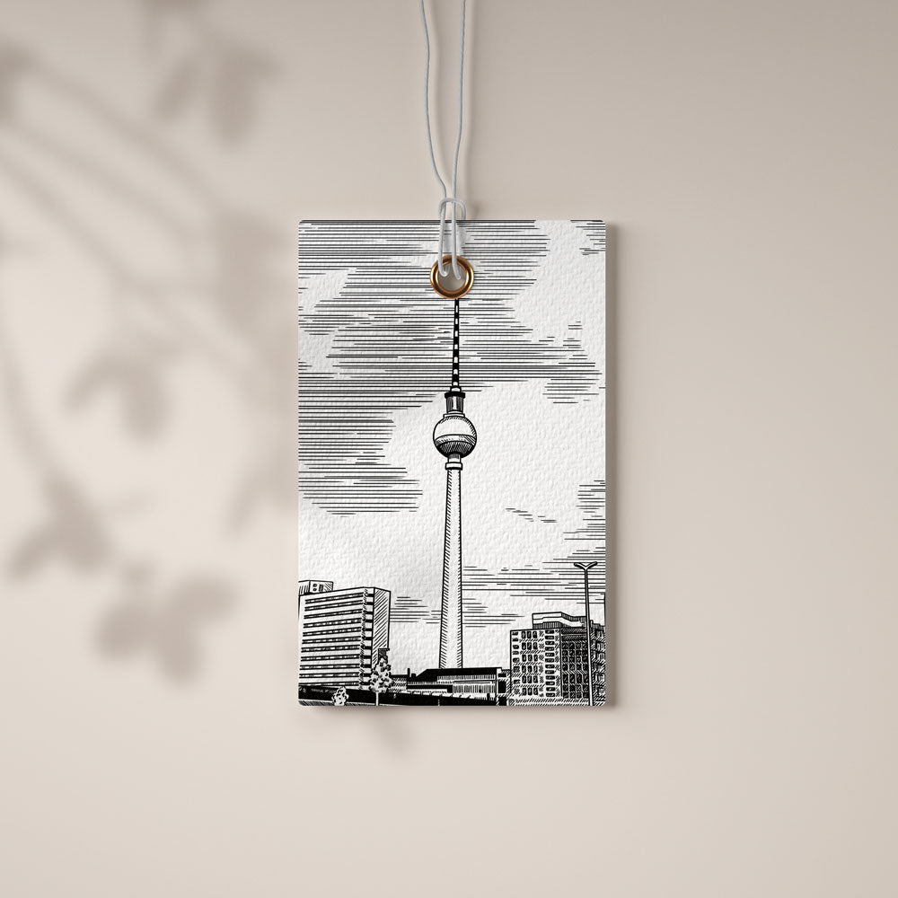 Stimmungsbild zu »1984. Einer dieser Sommer.«: Tuschezeichnung des Berliner Fernsehturms auf einem Papieranhänger, der an einer Schnur vor einer hellen Wand hängt.