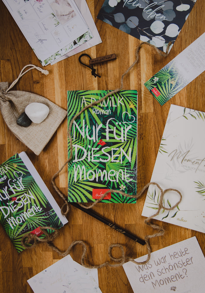Taschenbuch »Nur für diesen Moment« von A.D. WiLK als Buchpaket, in Szene gesetzt.