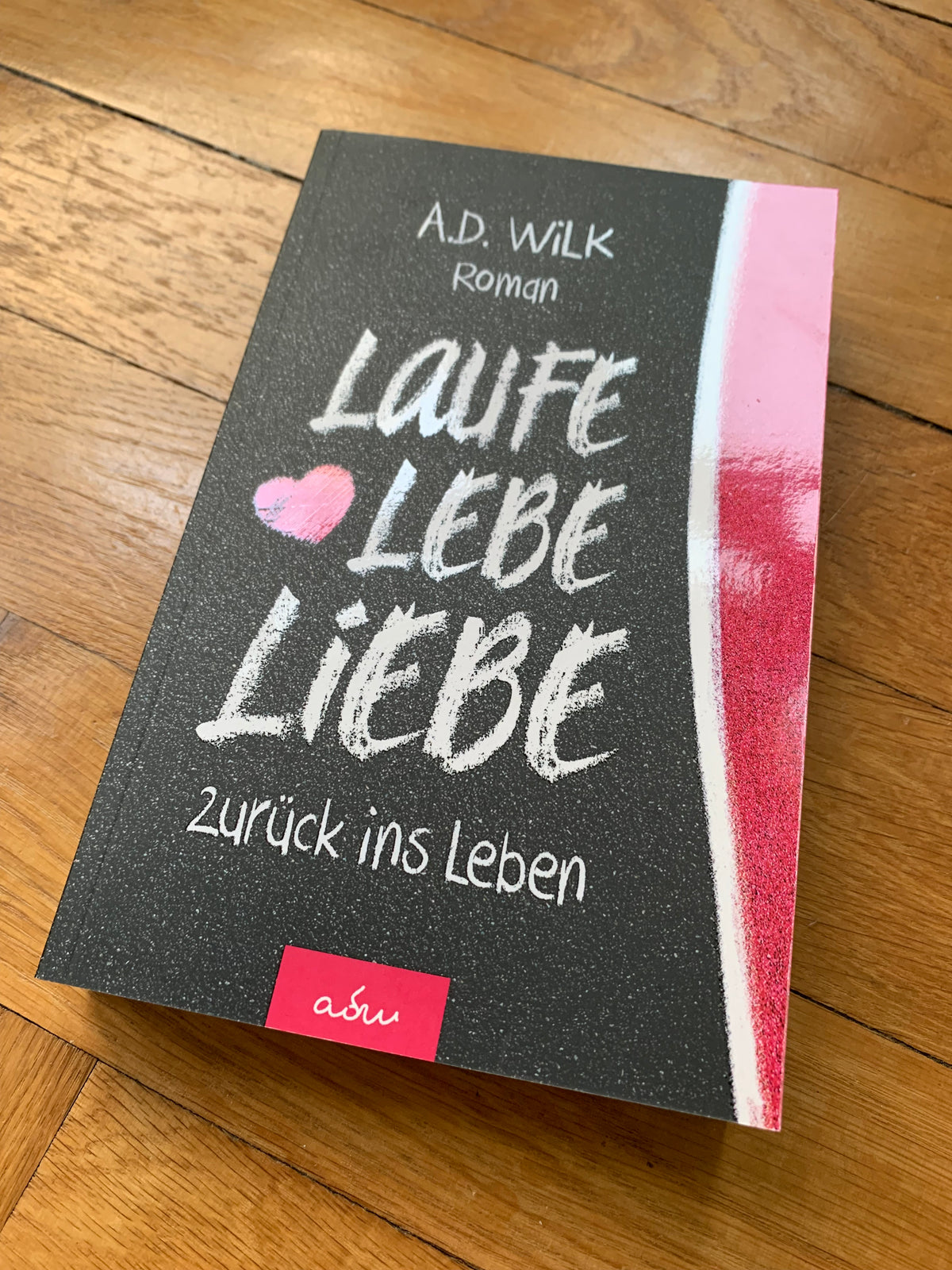 Taschenbuch »Laufe Lebe Liebe« von A.D. WiLK, in Szene gesetzt.